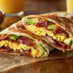 Delicious homemade tasty breakfast wrap with eggs, bacon, and avocado.